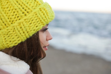 Photo of Young woman in warm clothes time near sea