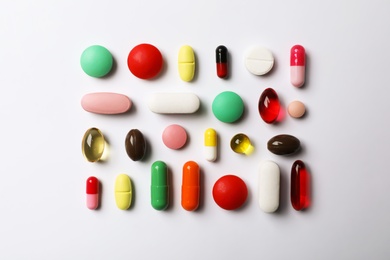 Flat lay composition with different pills on white background. Medical objects