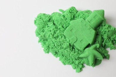 Photo of Castle and starfish made of green kinetic sand isolated on white, top view