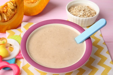 Photo of Plate of healthy baby food on color table