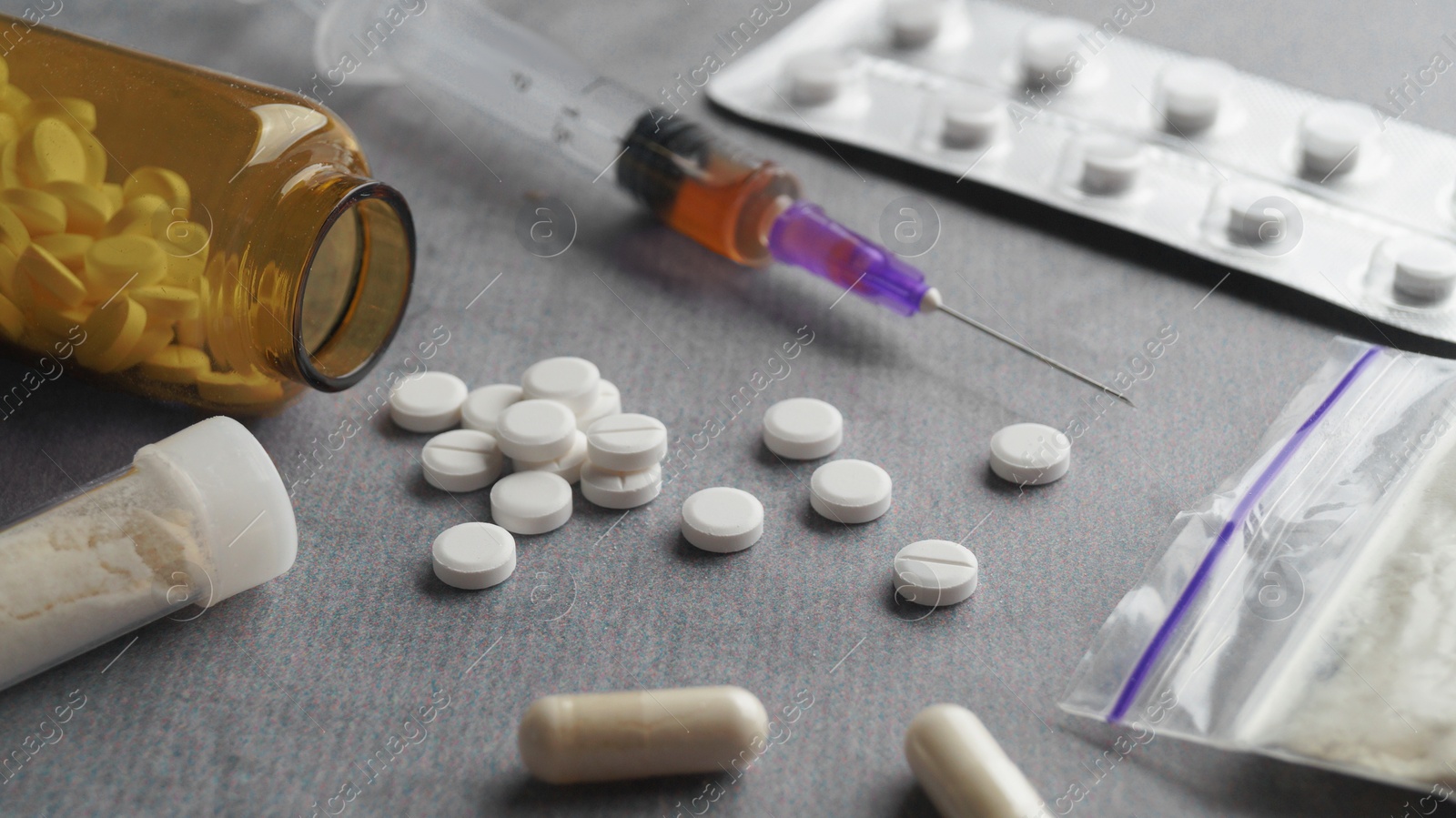 Photo of Different hard drugs on light grey table, closeup