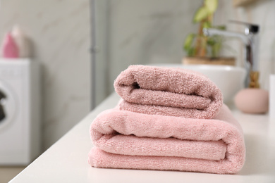 Photo of Stack of clean towels on bathroom countertop. Space for text