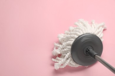 Photo of Mop with metal handle on pink background, top view. Space for text