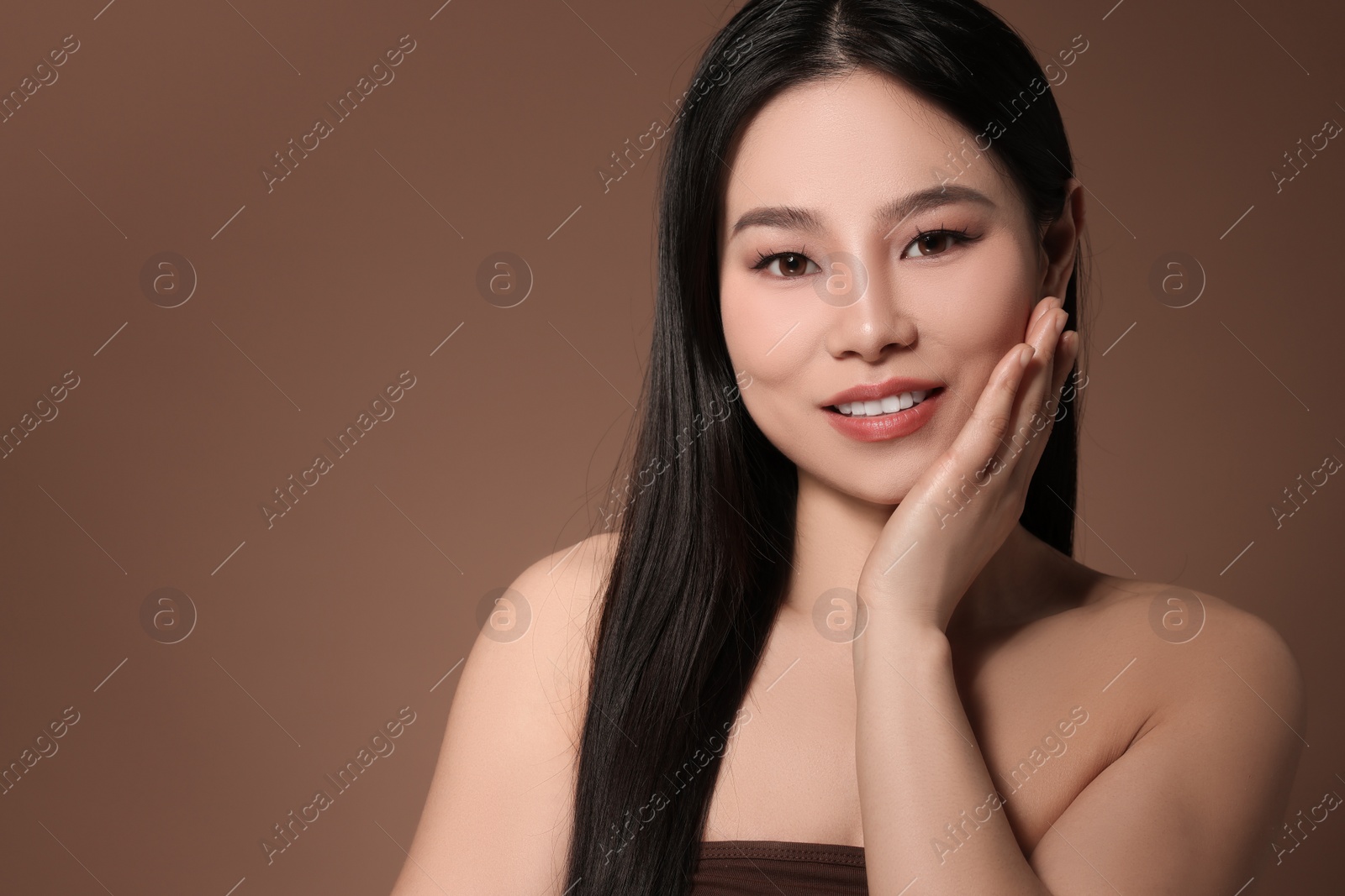 Photo of Portrait of beautiful woman on brown background, space for text