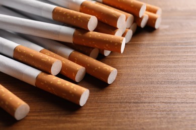 Pile of cigarettes on wooden table, closeup