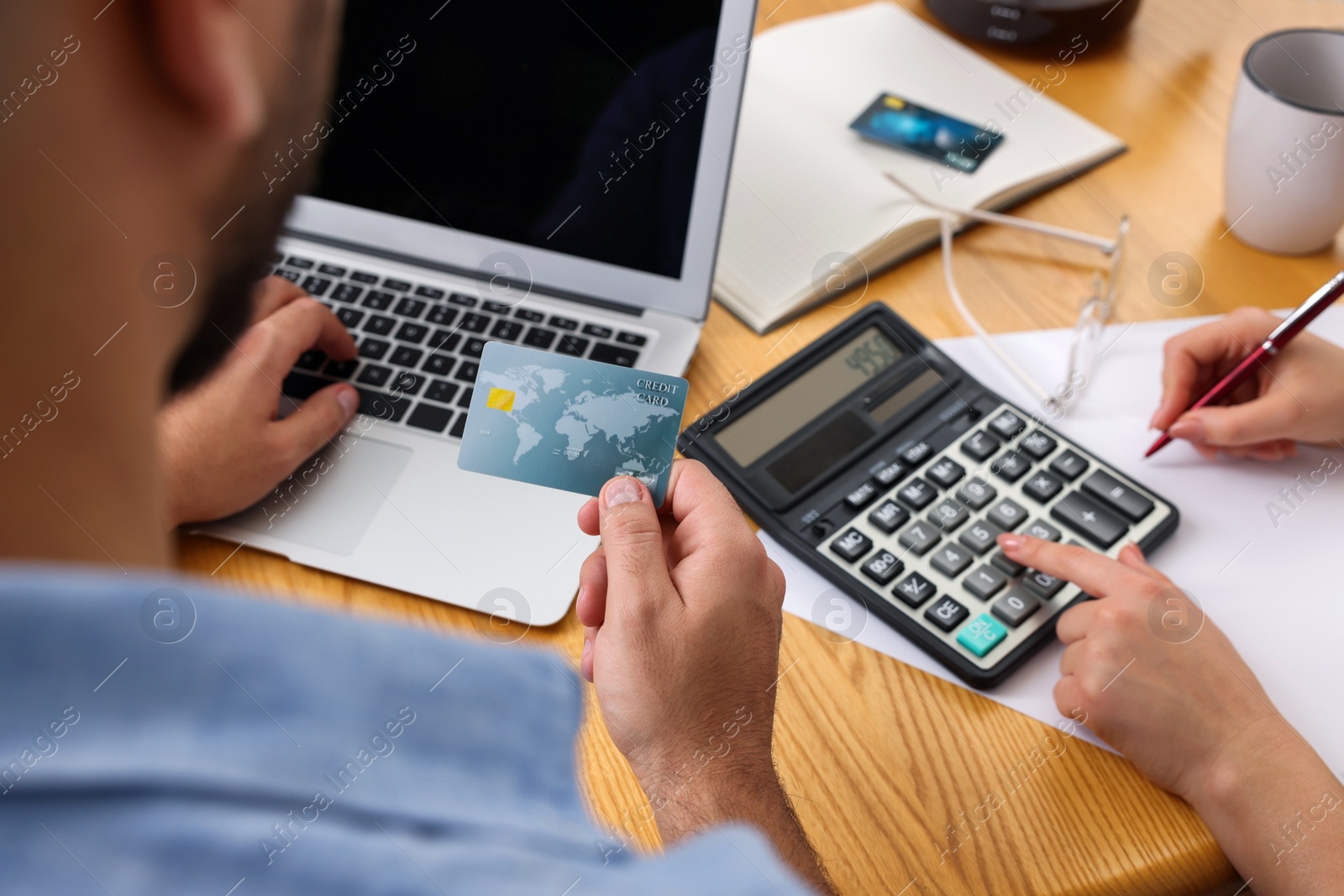 Photo of Young couple discussing family budget at table, closeup