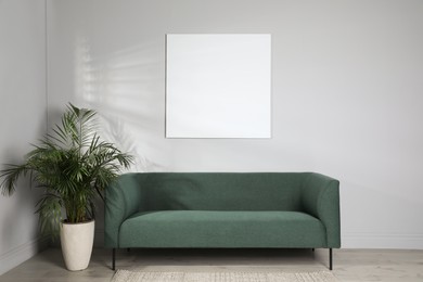 Living room interior with green sofa and blank canvas. Space for design