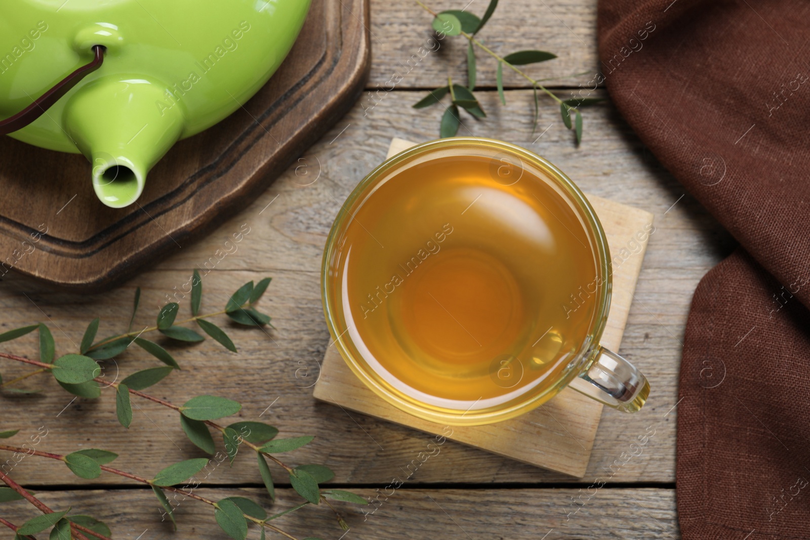 Photo of Aromatic eucalyptus tea on wooden table, flat lay