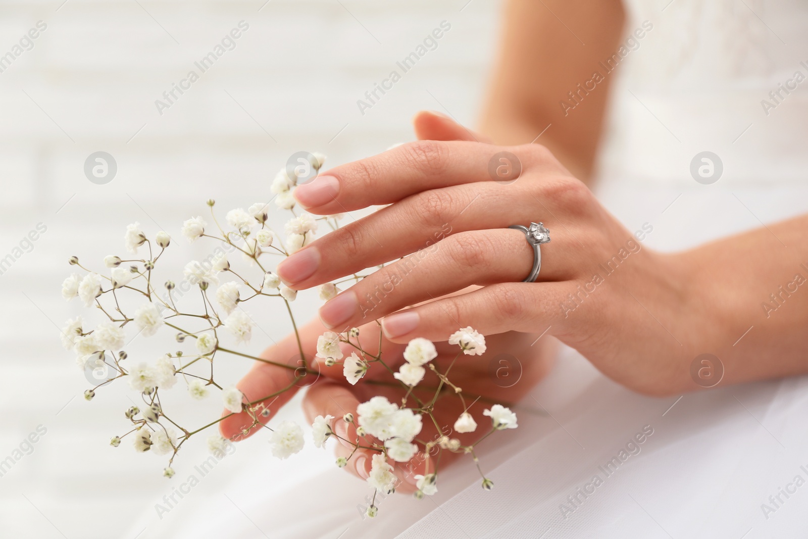 Photo of Young bride wearing beautiful engagement ring, closeup