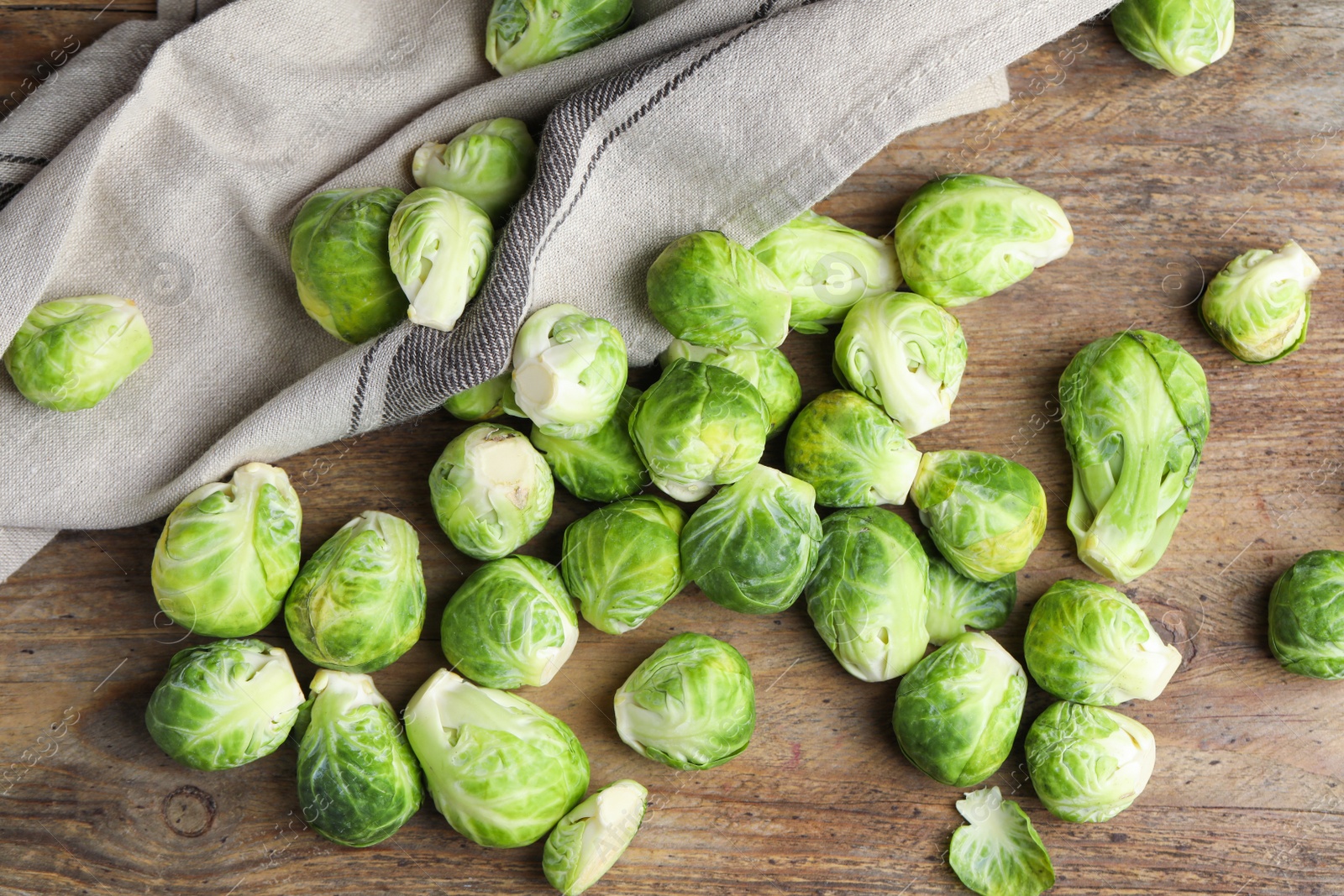 Photo of Fresh Brussels sprouts on wooden table, flat lay