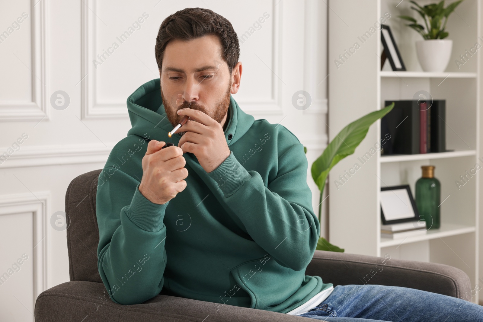 Photo of Man using cigarette holder for smoking indoors