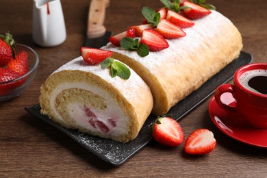 Delicious cake roll with strawberries and cream on wooden table