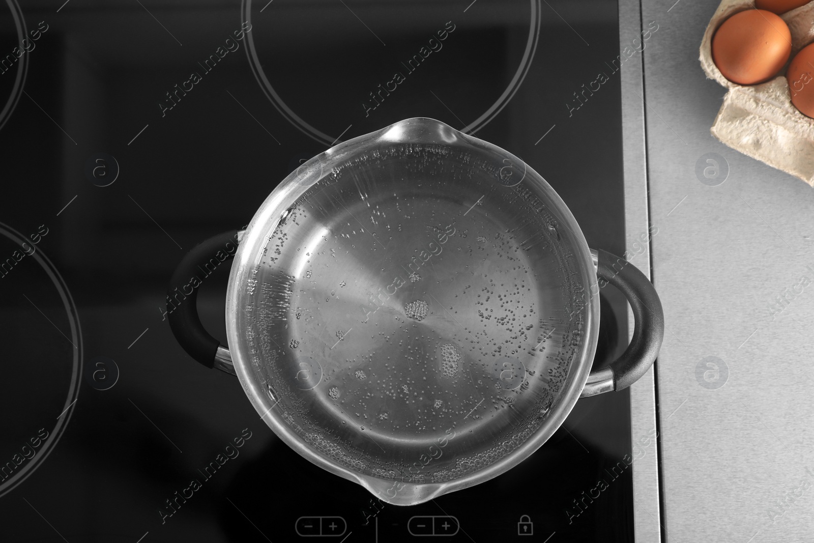 Photo of Pot with boiling water on electric stove in kitchen, top view