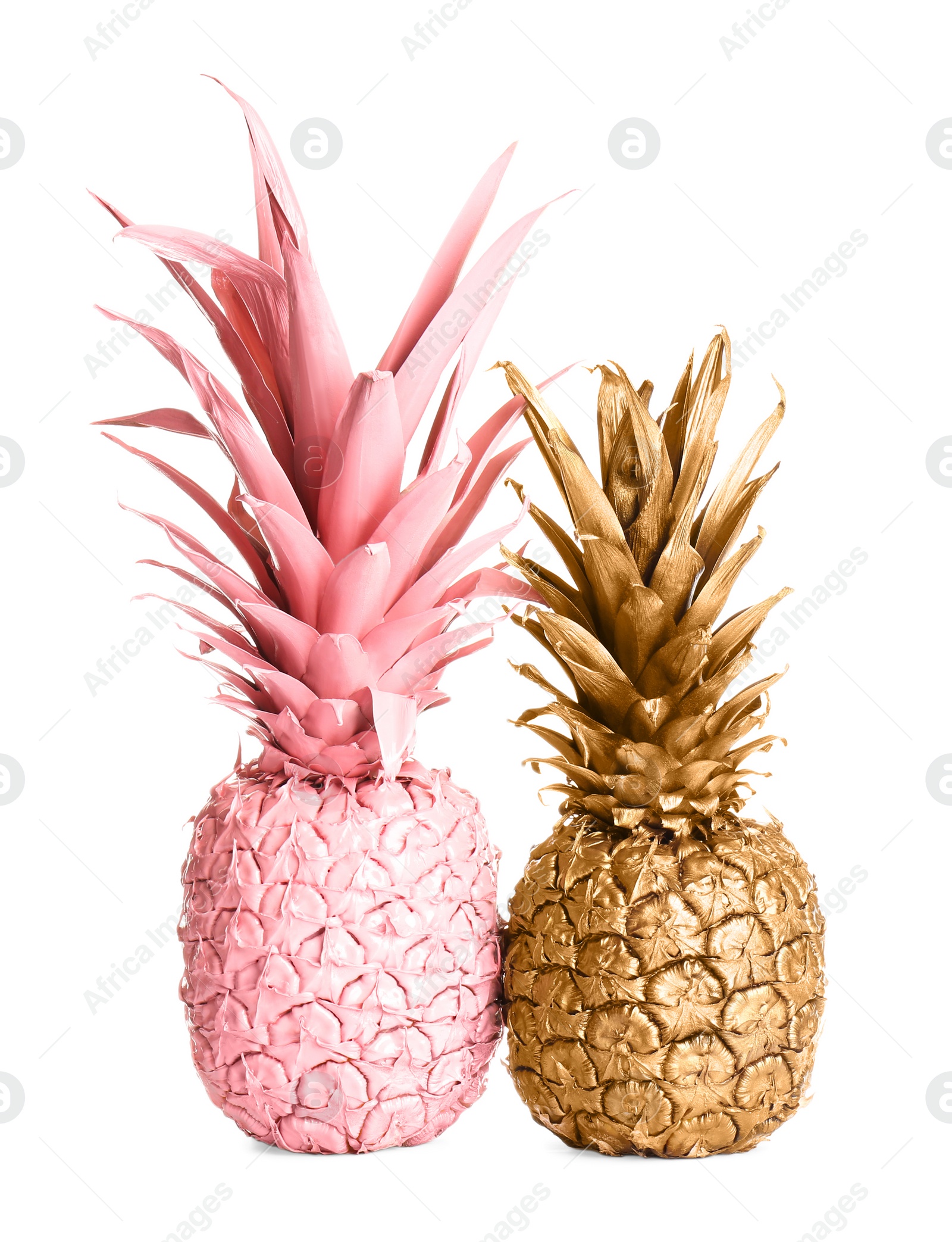Photo of Gold and pink painted fresh pineapples on white background