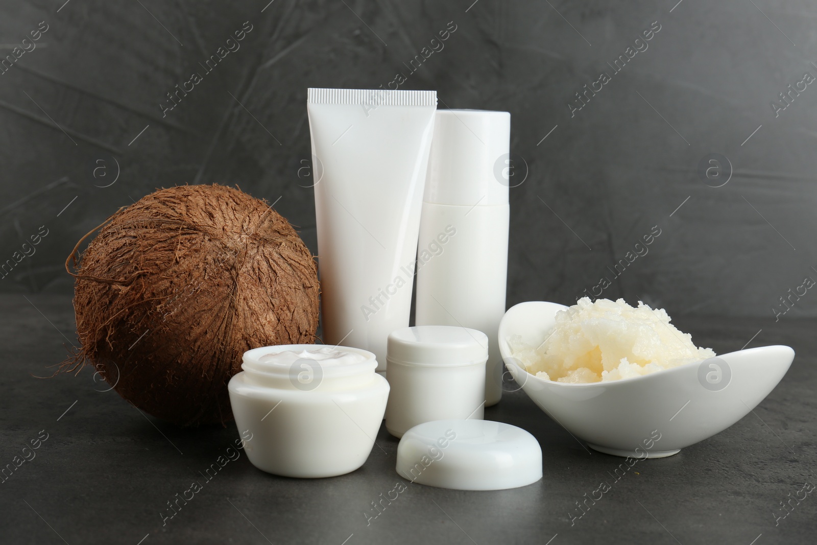 Photo of Homemade cosmetic products and coconut on black table