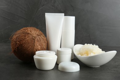 Photo of Homemade cosmetic products and coconut on black table