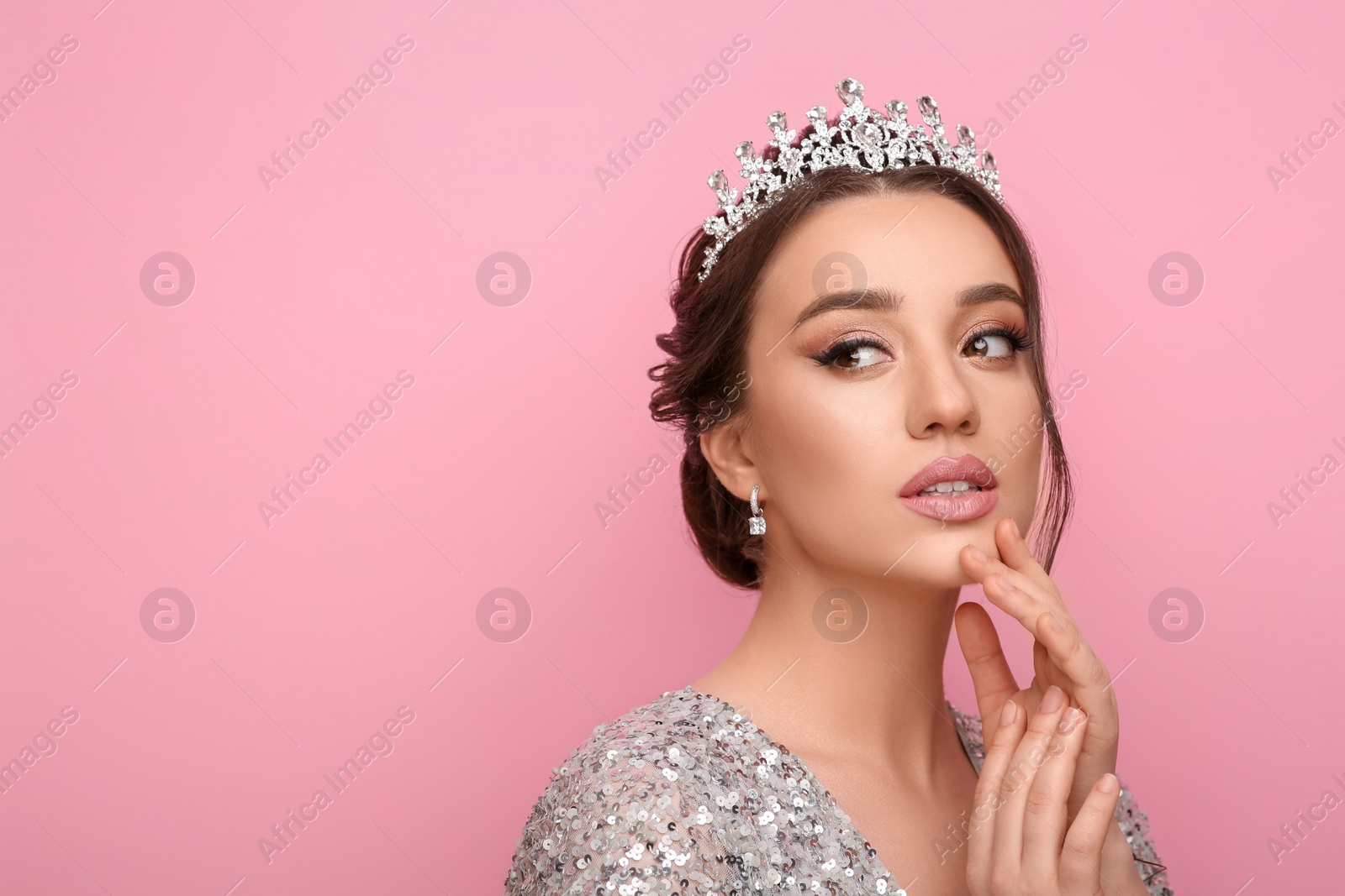 Photo of Beautiful young woman wearing luxurious tiara on pink background, space for text