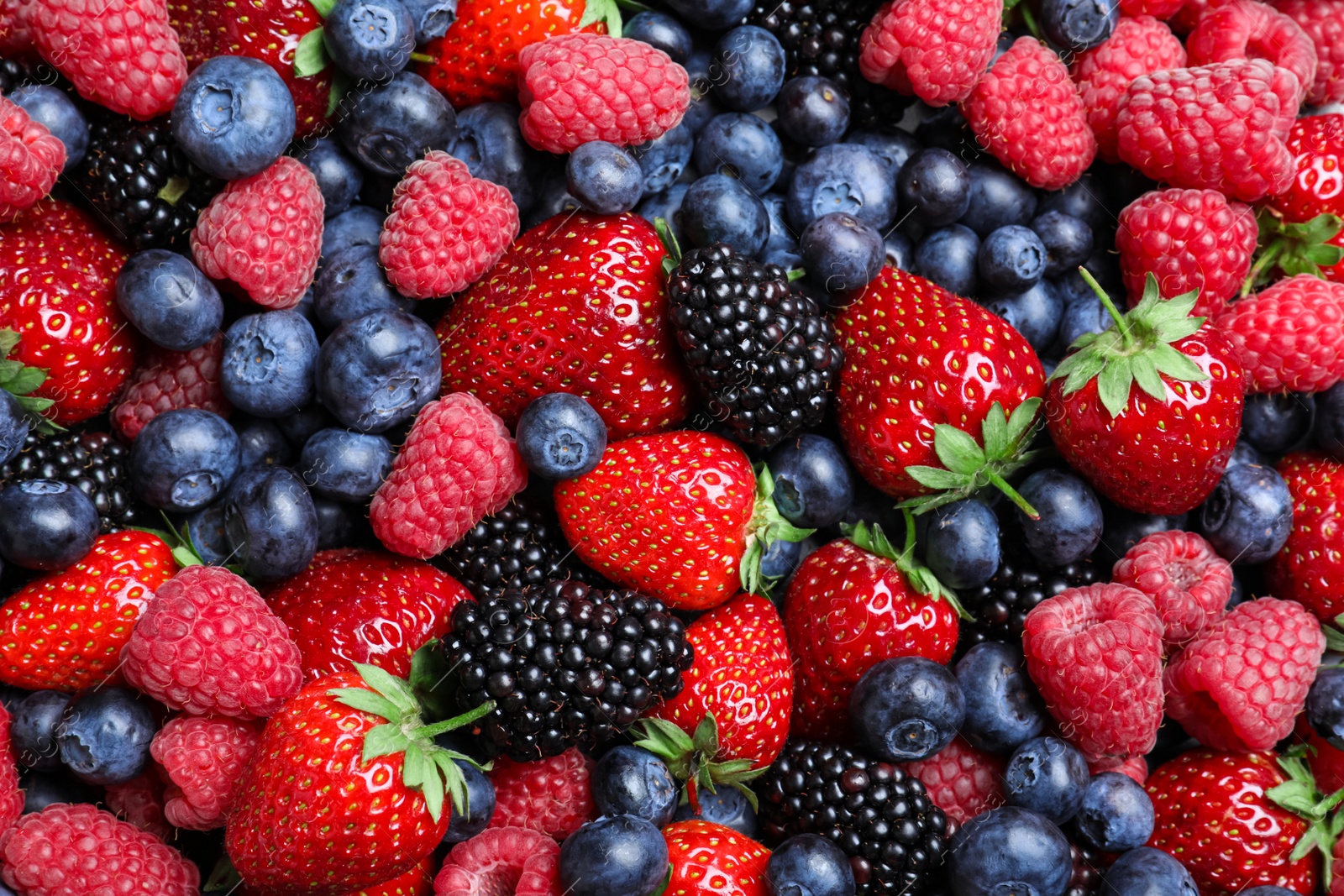 Photo of Mix of different ripe tasty berries as background, top view