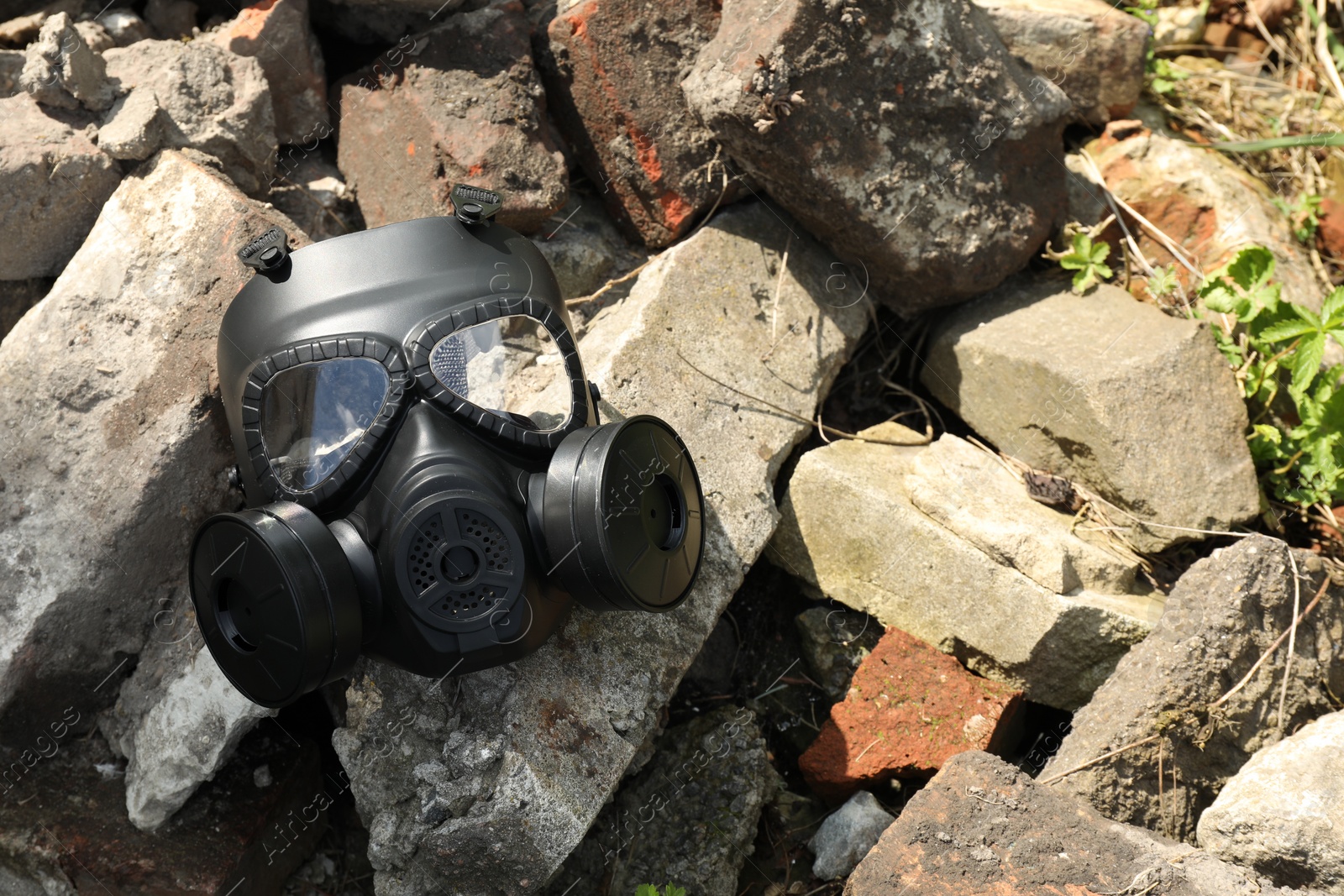 Photo of One gas mask on stones outdoors, space for text