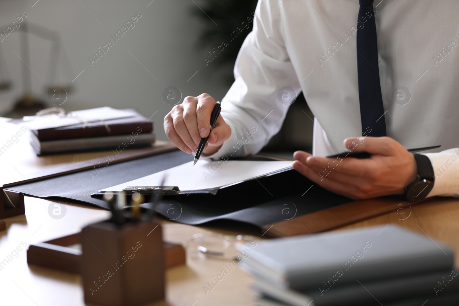 Photo of Male lawyer working at table in office, closeup