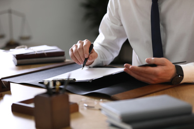 Photo of Male lawyer working at table in office, closeup