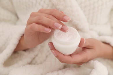 Photo of Woman holding open jar with cream, closeup