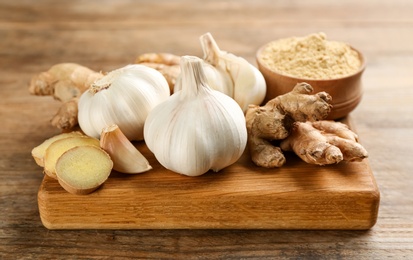 Photo of Ginger and fresh garlic on wooden table. Natural cold remedies
