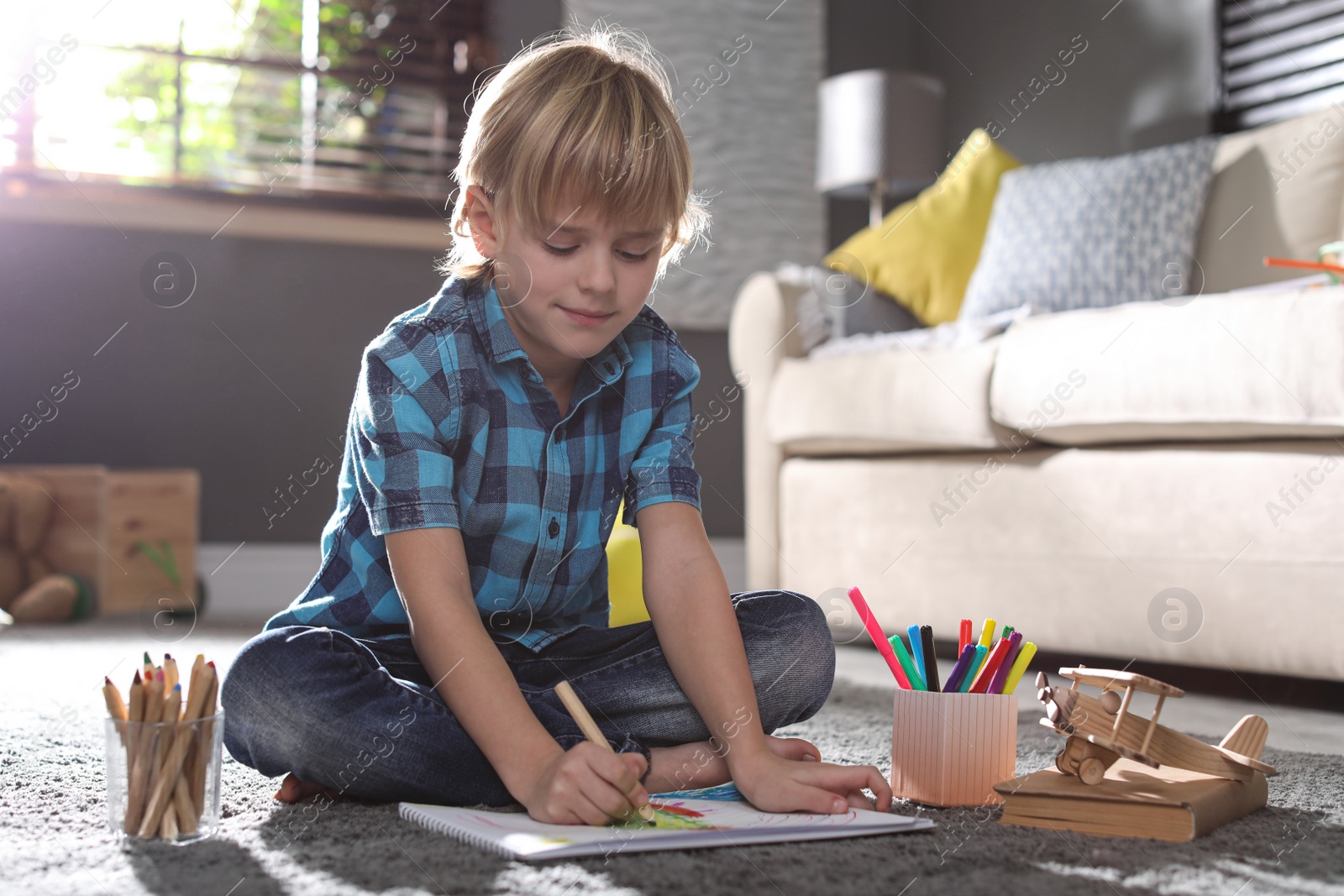 Photo of Little boy drawing on floor at home. Creative hobby
