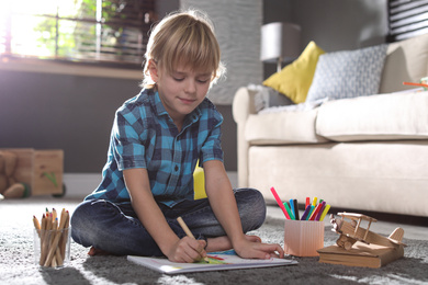 Little boy drawing on floor at home. Creative hobby