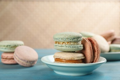 Photo of Delicious macarons on light blue wooden table