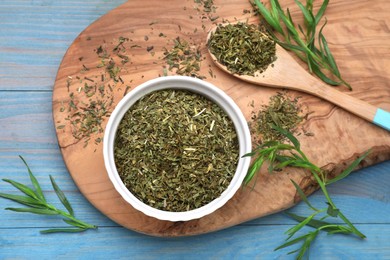 Photo of Dry and fresh tarragon on light blue wooden table, flat lay