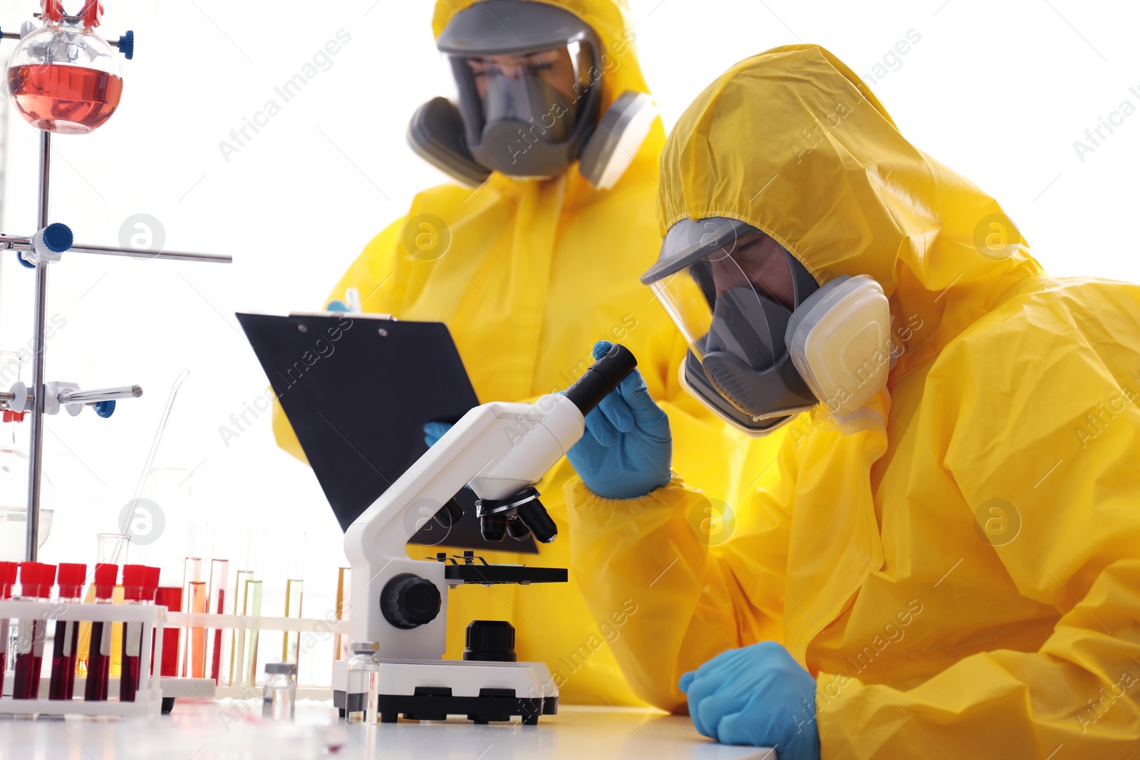 Photo of Scientists in chemical protective suits working at laboratory. Virus research