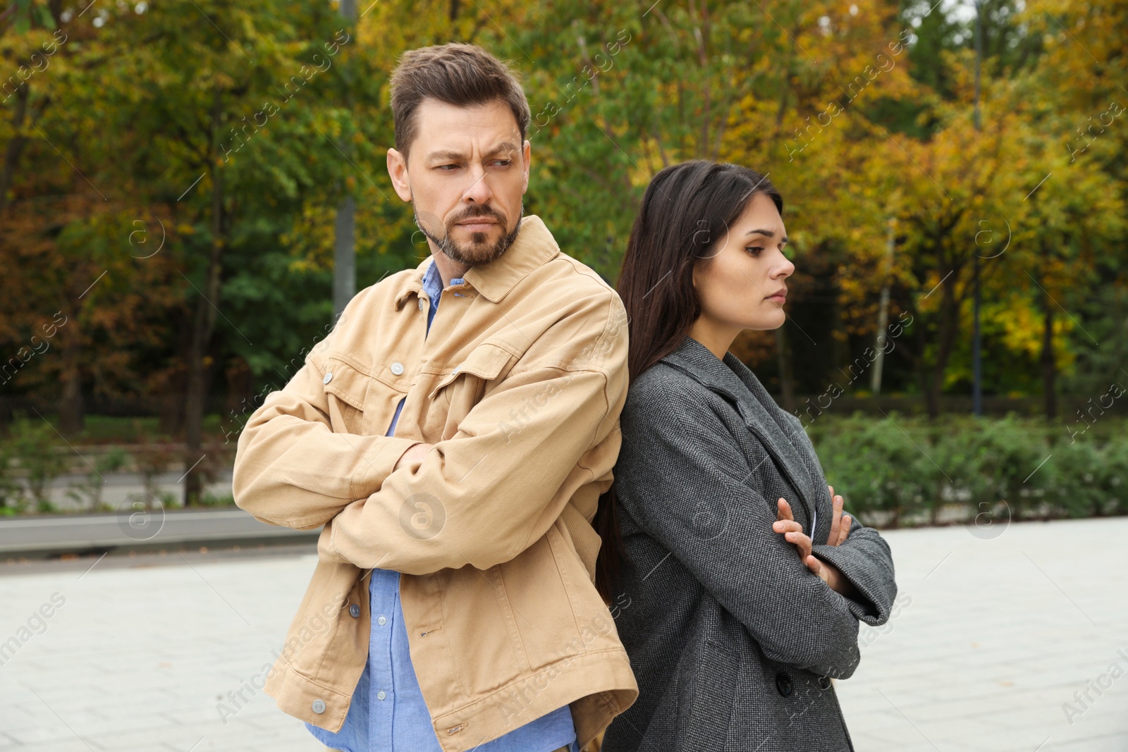 Photo of Upset arguing couple in park. Relationship problems