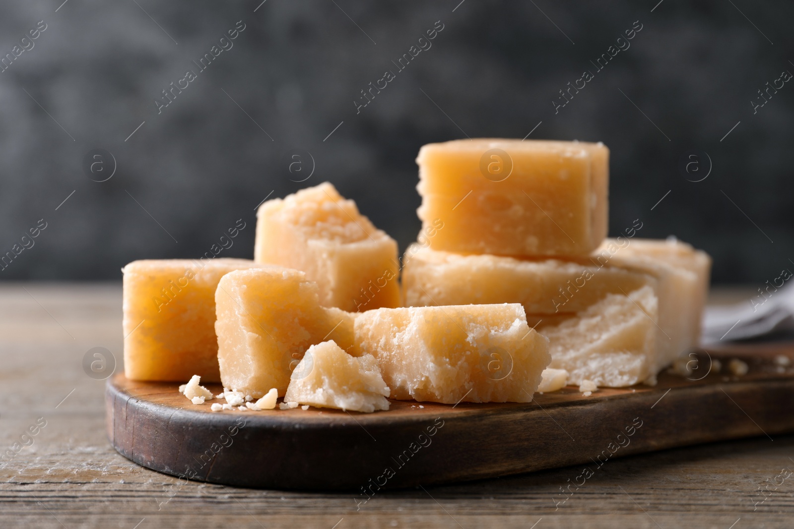 Photo of Pieces of delicious parmesan cheese on wooden table, closeup