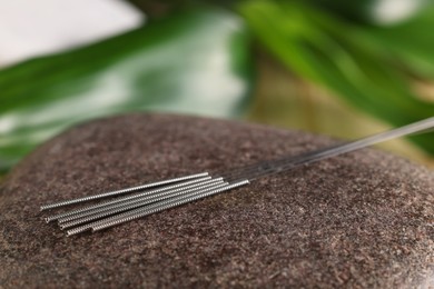 Photo of Acupuncture needles on spa stone, closeup view