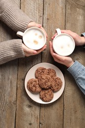 Photo of Women having coffee break at wooden table, top view