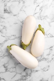 Ripe white eggplants on marble table, flat lay