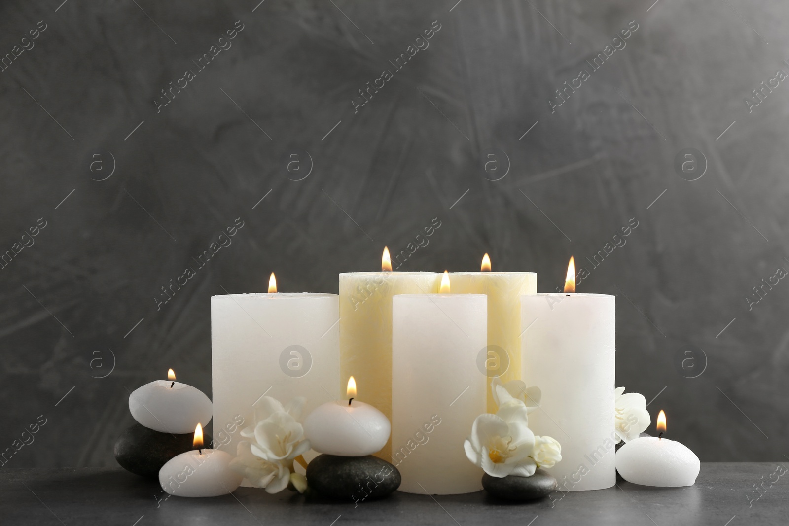 Photo of Beautiful composition with lit candles and flowers on table