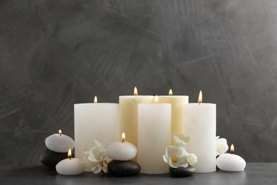 Photo of Beautiful composition with lit candles and flowers on table