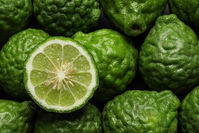 Whole and cut ripe bergamot fruits as background, top view