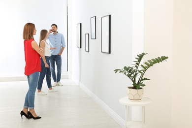 Photo of People viewing exposition in modern art gallery