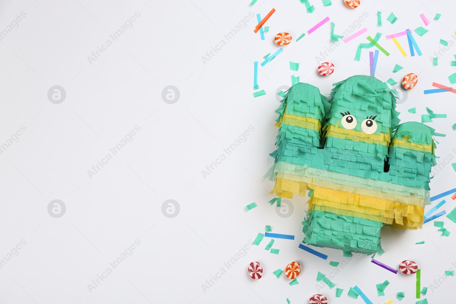 Photo of Composition with cactus shaped pinata and candies on white background, top view
