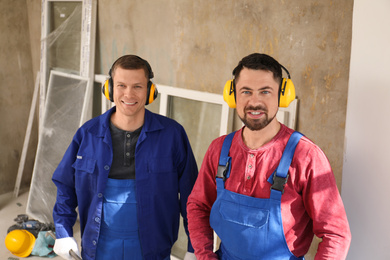 Photo of Portrait of workers with equipment indoors. Window installation