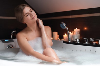 Photo of Beautiful woman taking bubble bath indoors. Romantic atmosphere