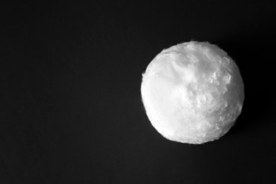 Photo of Ball of clean cotton wool on dark background. Space for text