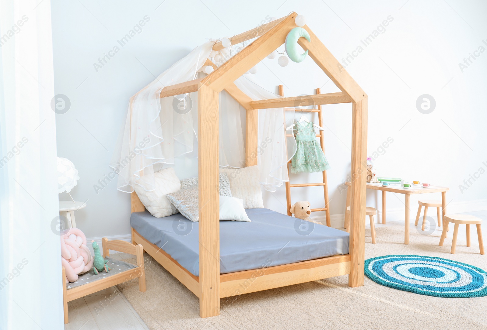 Photo of View of cozy child's room interior with cute bed