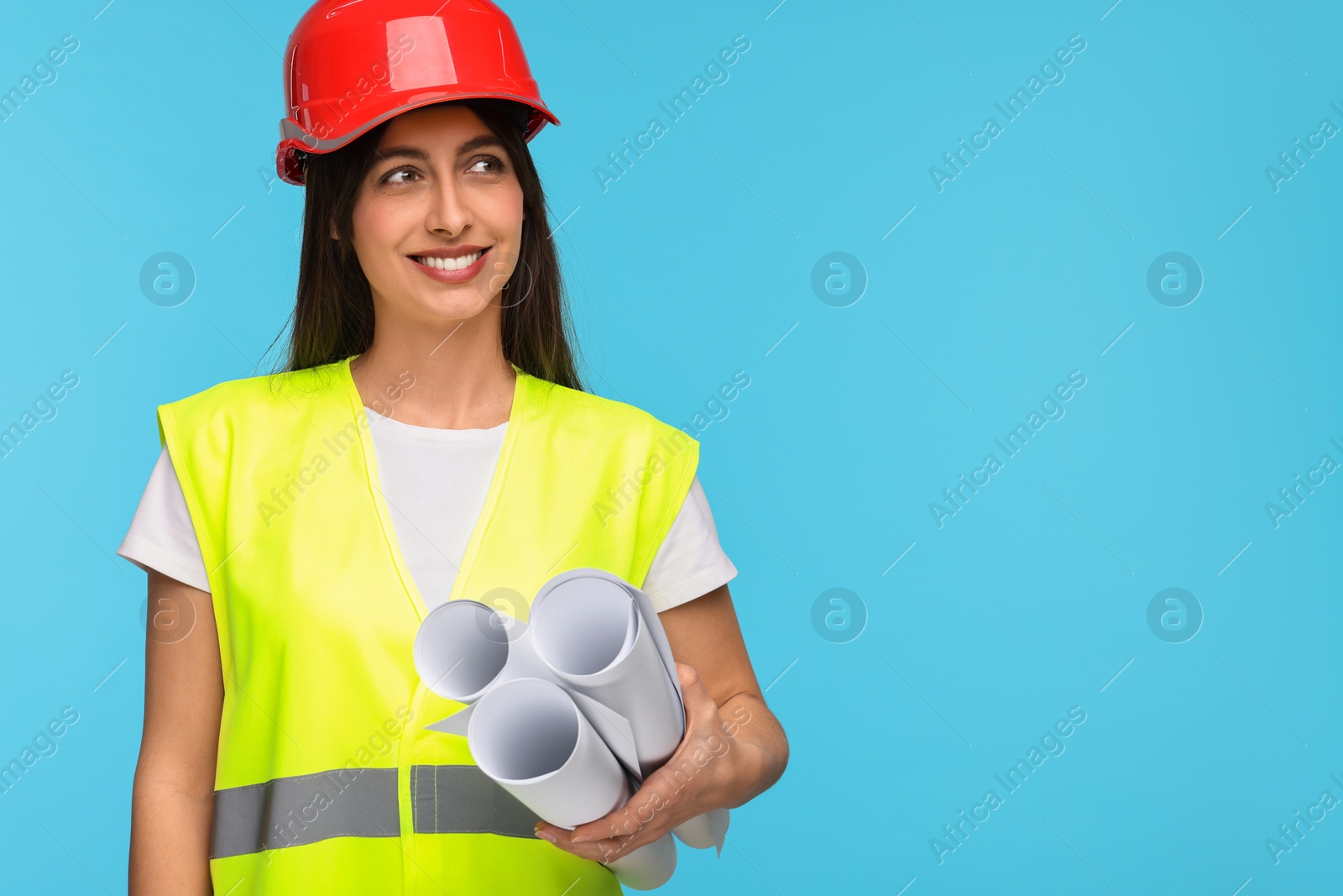 Photo of Architect in hard hat with drafts on light blue background, space for text