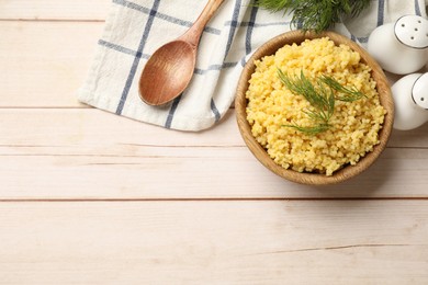 Photo of Tasty millet porridge and dill in bowl on light wooden table, flat lay. Space for text