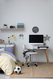 Stylish teenager's room interior with comfortable bed and workplace