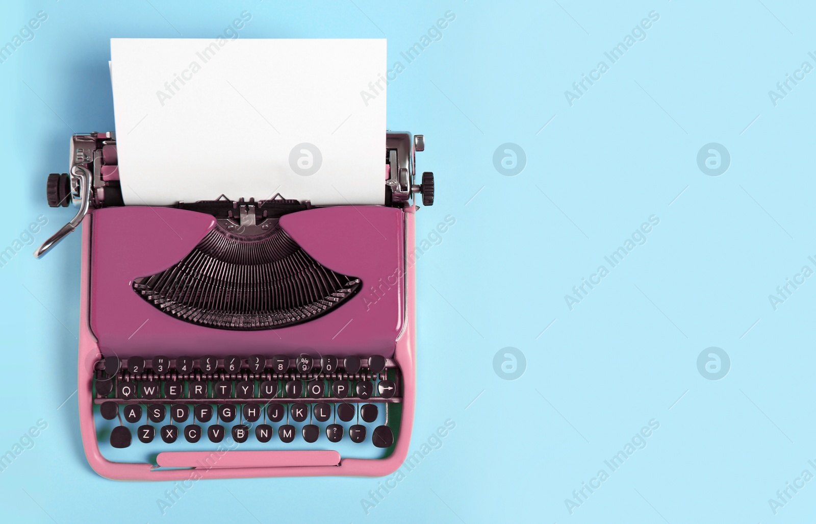 Image of Copywriter. Vintage typewriter on light blue background, top view. Space for text